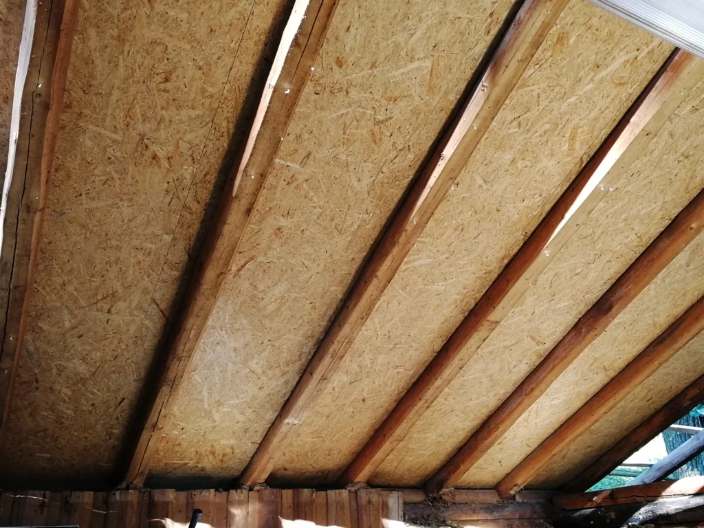 Dachbalken mit neuen dahinterliegenden Spanplatten
