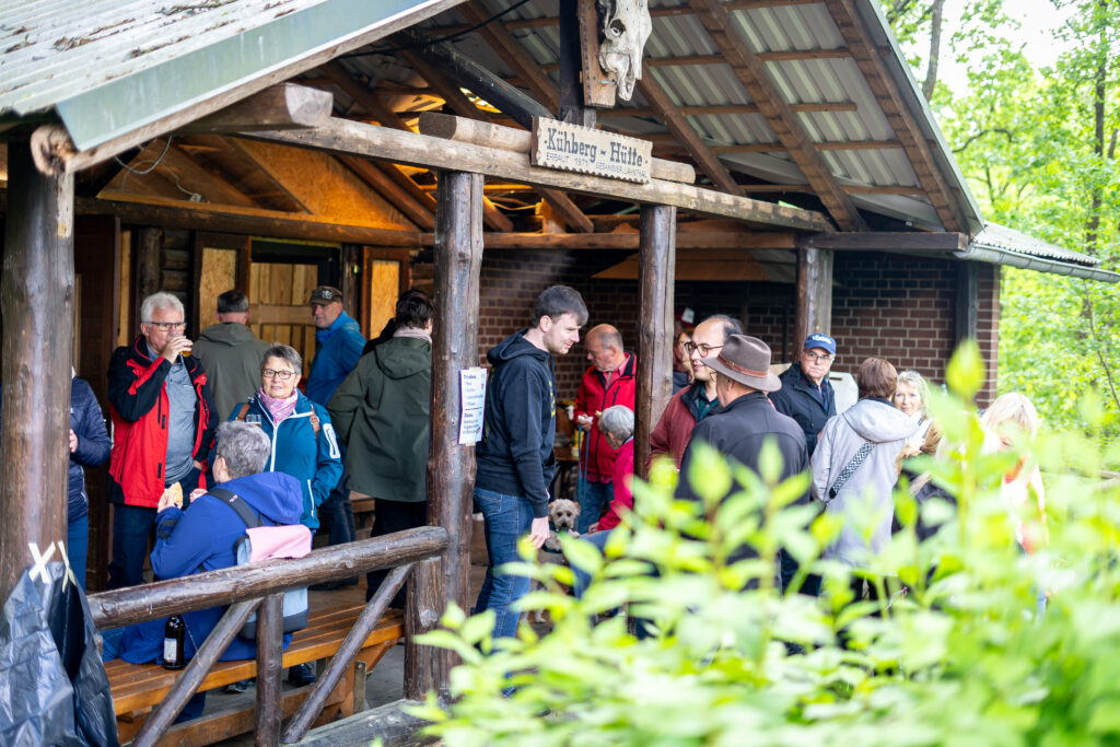 Blick unter den Vorbau des Kühbergs, es stehen viele Menschen dort und unterhalten sich